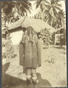229253 Vrouw van de Marind-anim poseert bij de statie in Merauke (Indonesië). Achteraanzicht